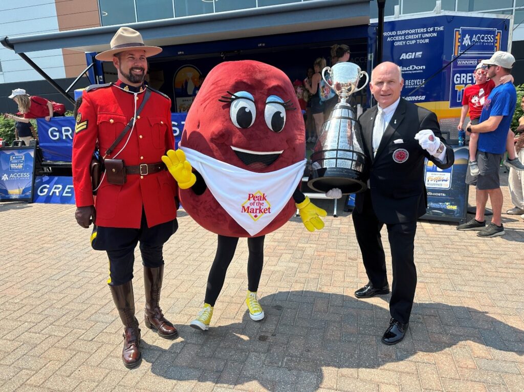 Peak of the Market’s mascot, Rosie the Red Potato, poses with the Grey Cup